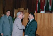 الدكتور محمد عمارة يصافح الدكتور الشميري ويظهر خلفهم طلعت حامد المستشار بالجامعة العربية